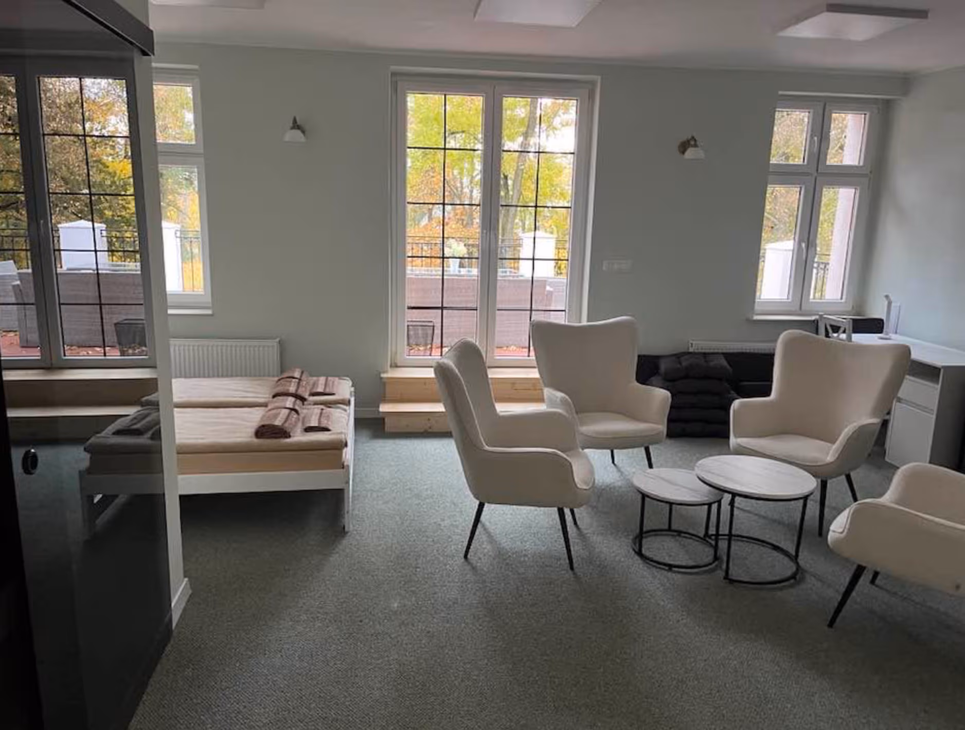 Jasny, przestronny pokój z fotelami i widokiem na park